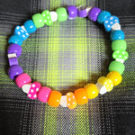 Colorful beaded bracelet on a plaid fabric background