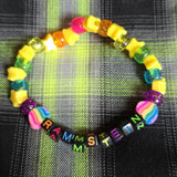 Colorful beaded bracelet with letter beads on a plaid fabric background