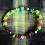 Colorful beaded bracelet with letter beads on a plaid fabric background