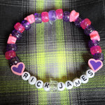 Colorful beaded bracelet with 'RICK JAMES' on a plaid fabric background
